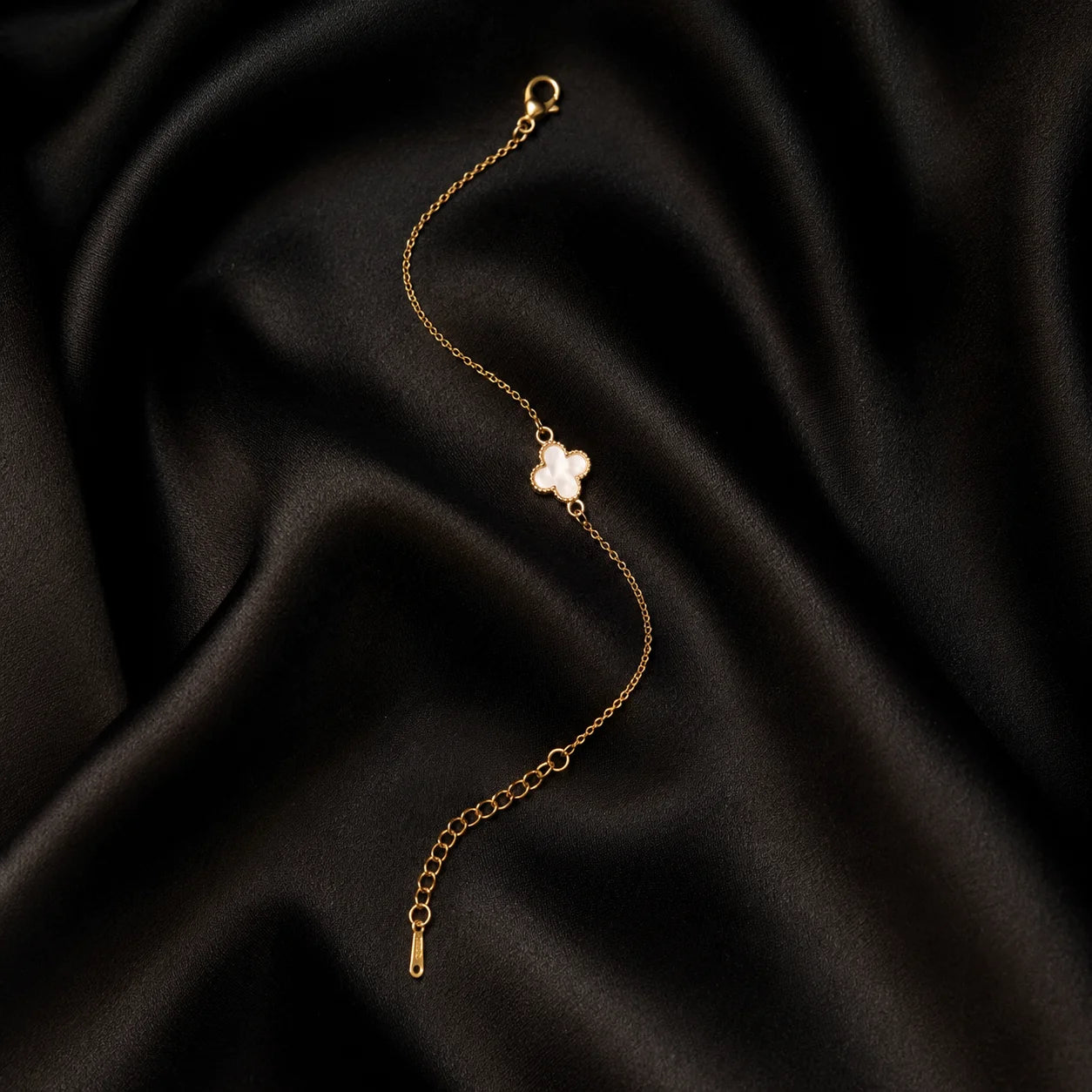 Gold chain bracelet with a white clover centerpiece full product view