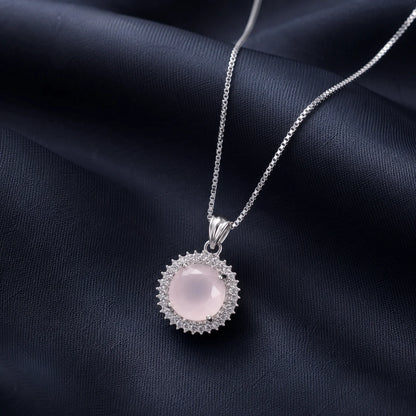 Silver necklace with round pink sunburst pendant close-up