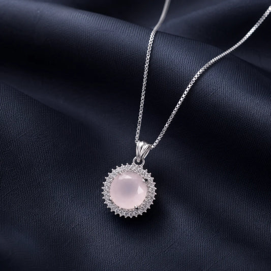 Silver necklace with round pink sunburst pendant close-up