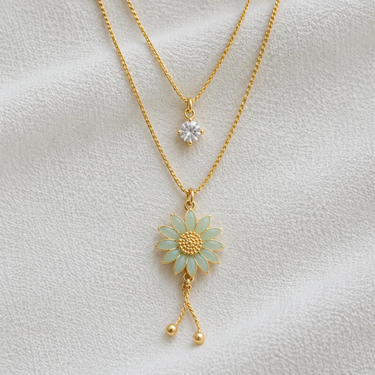 Layered gold necklace with mint flower pendant close-up
