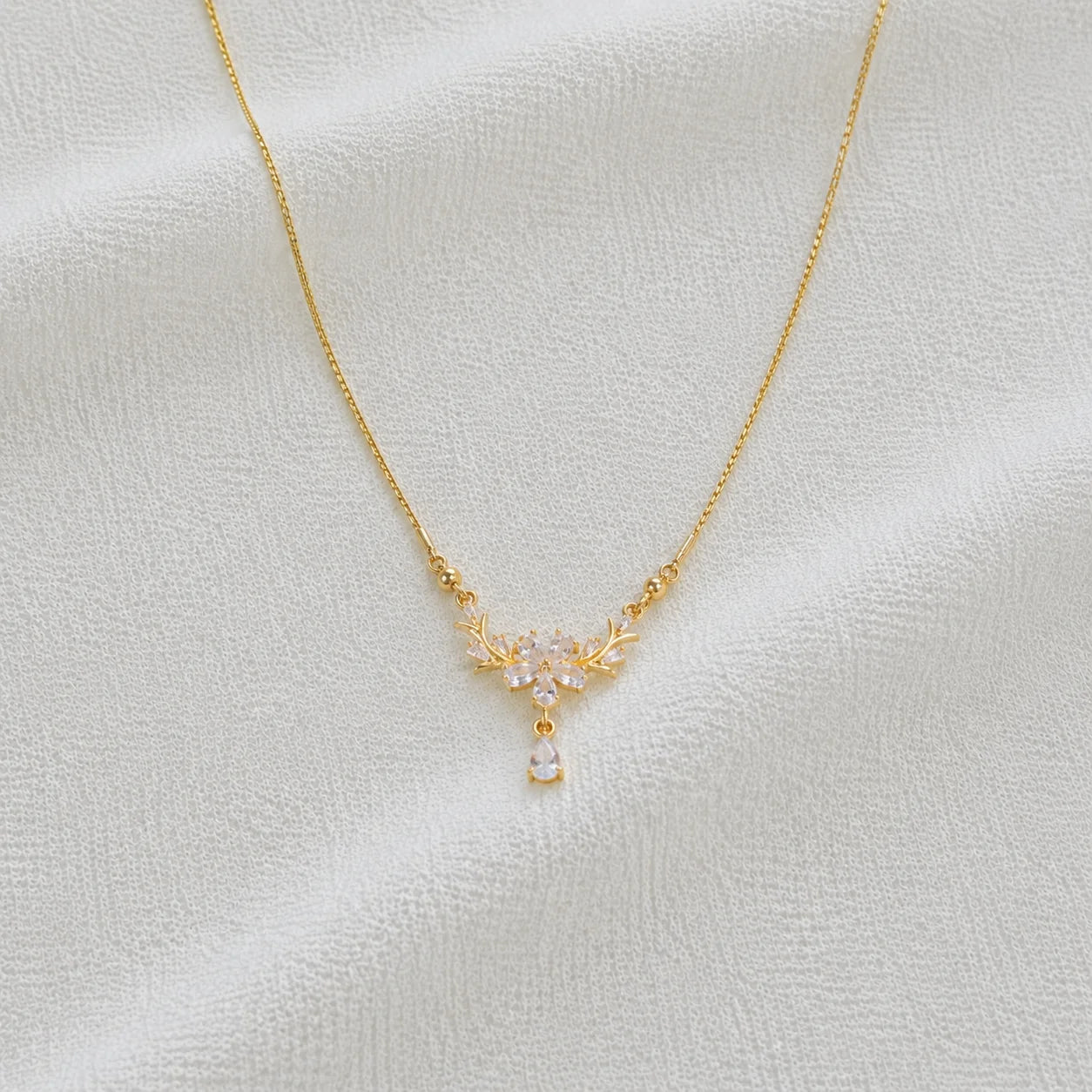 Delicate gold necklace with crystal floral pendant close-up