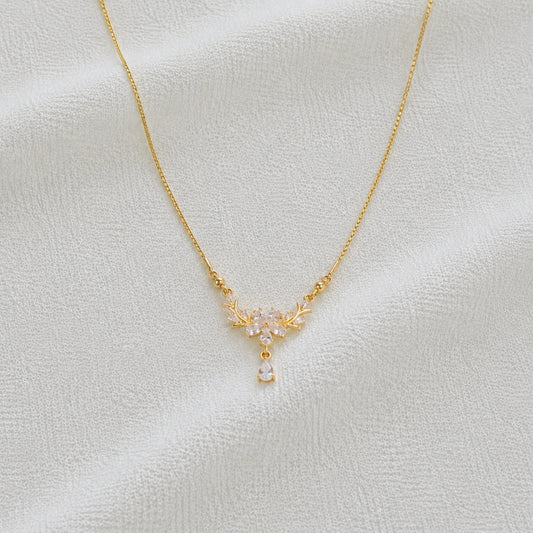 Delicate gold necklace with crystal floral pendant close-up
