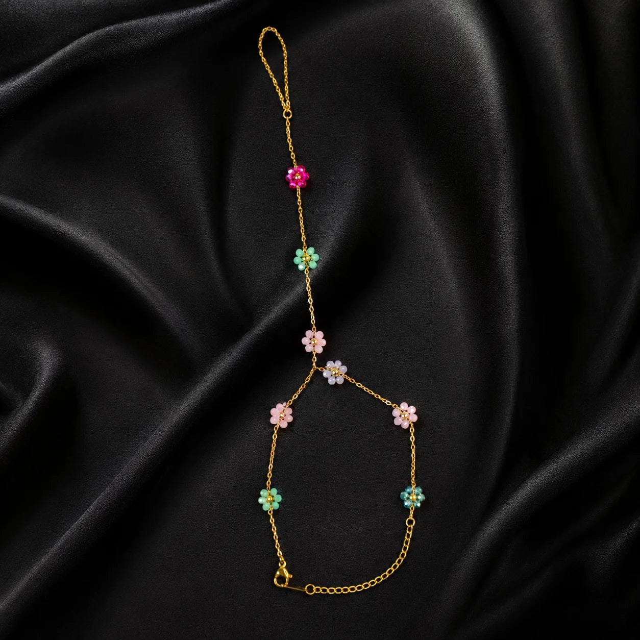 Multicolor floral gold hand chain shown flat in a full product view