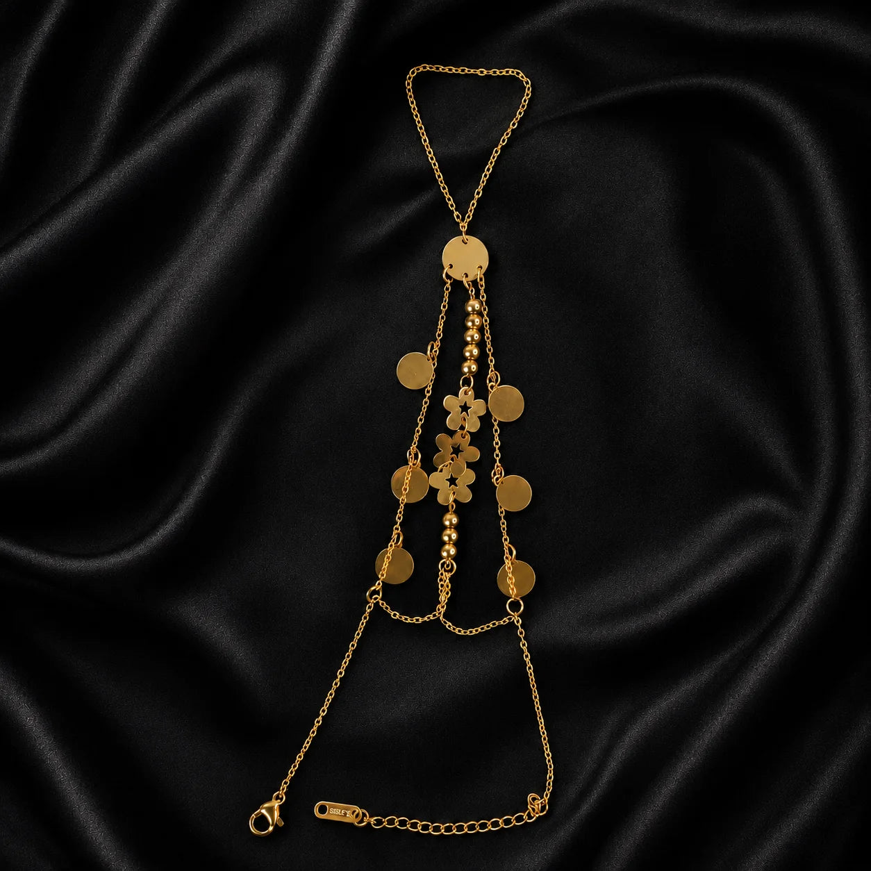 Gold hand chain with cascading floral and coin charms shown flat