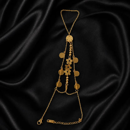 Gold hand chain with cascading floral and coin charms shown flat